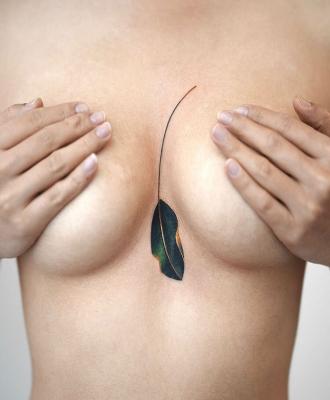 Kolorowy liść tatuaż między piersiami