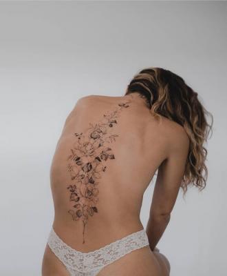 Kwiaty wzdłuż kręgosłupa damski tatuaż