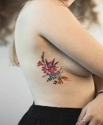 Piękne kwiaty tatuaż dziewczyna na żebrach