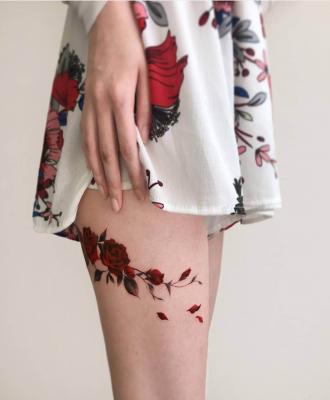 Tatuaż damski na udzie różyczka