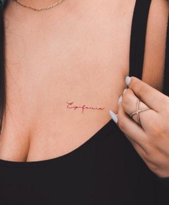 Tatuaż damski napis nad piersią