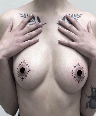 Tatuaż damski wokół sutków na piersi
