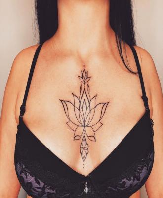 Tatuaż duży kwiat lotosu między piersiami