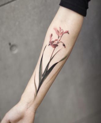 Tatuaż kobiecy na przedramieniu kwiat