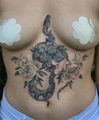 Tatuaż wąż i kwiaty między piersiami