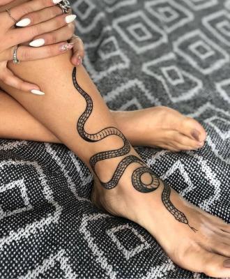 Tatuaż wąż na nodze damski