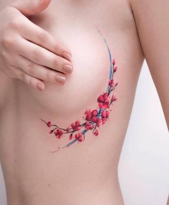 Tatuaże damskie koło piersi kwiaty