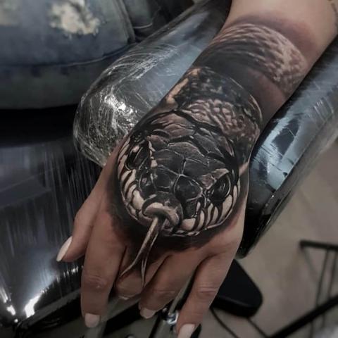 Damski tatuaż na dłoni wąż