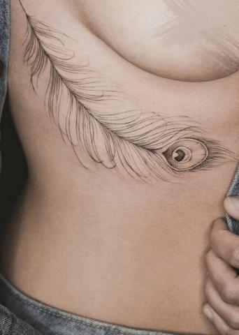Pawie pióro tatuaż damski