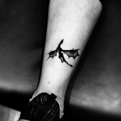 Tatuaż smok na nodze