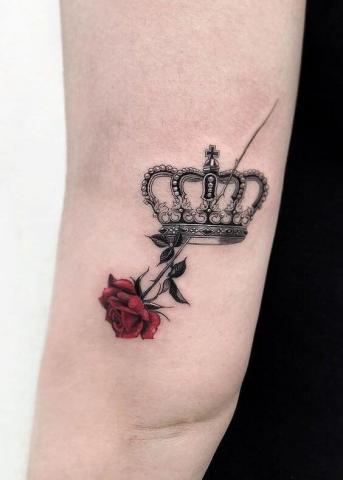 Tatuaż korona i róża na łokciu