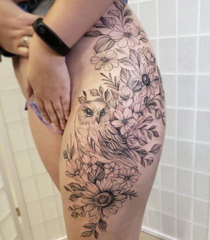 Tatuaż kwiaty i sowa na udzie