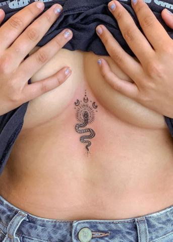 Tatuaż mały wąż między piersiami