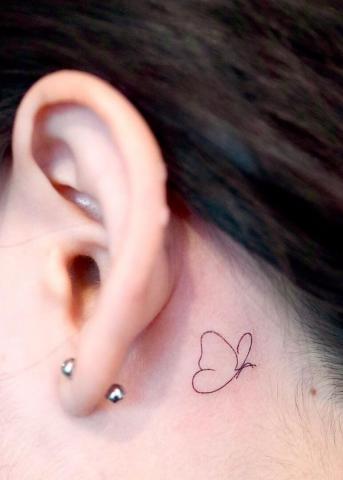 Tatuaż minimalistyczny motyl za uchem damski